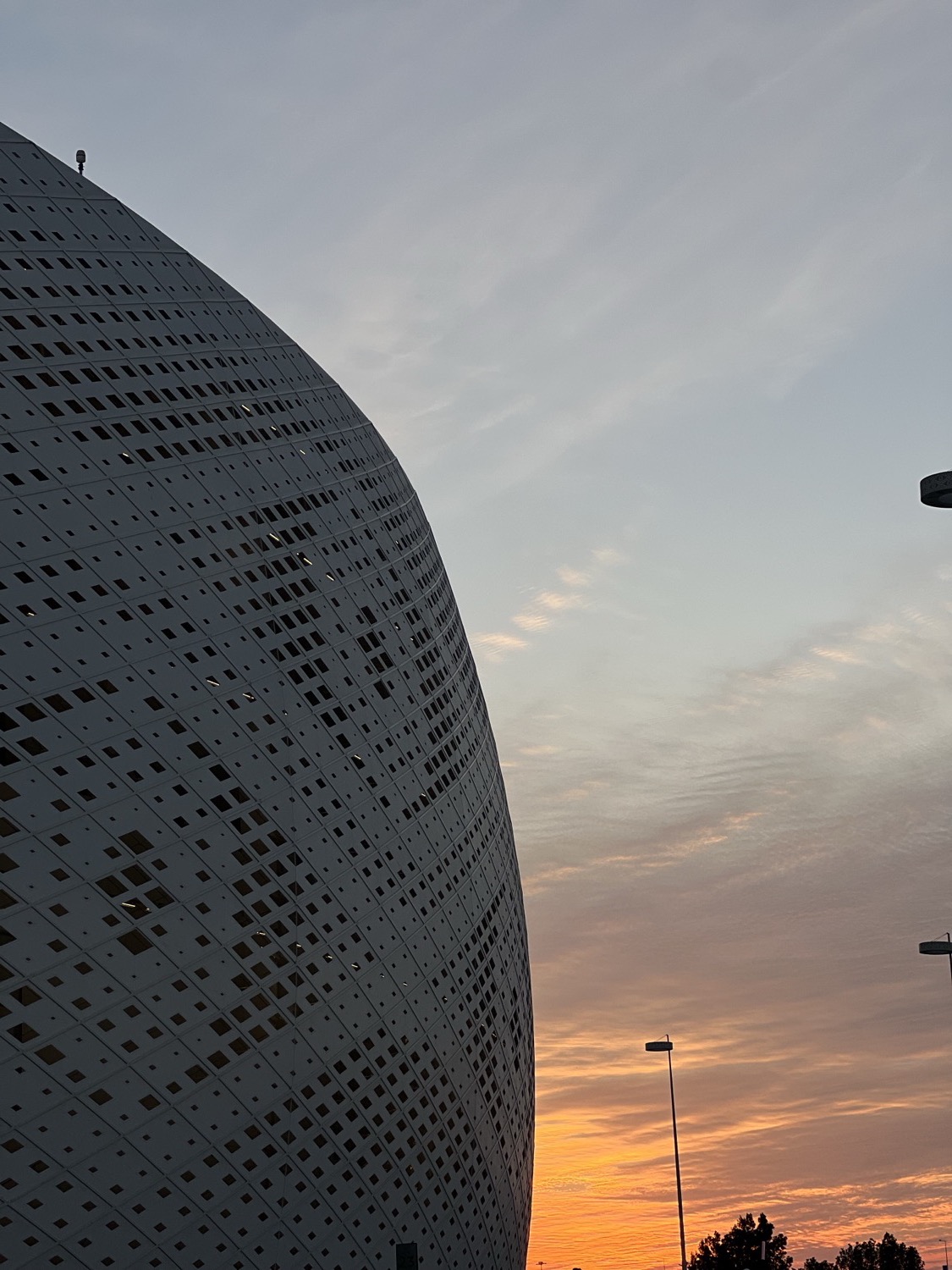 Perforated white stadium facade against the sunset, AFC Asian Cup, Doha