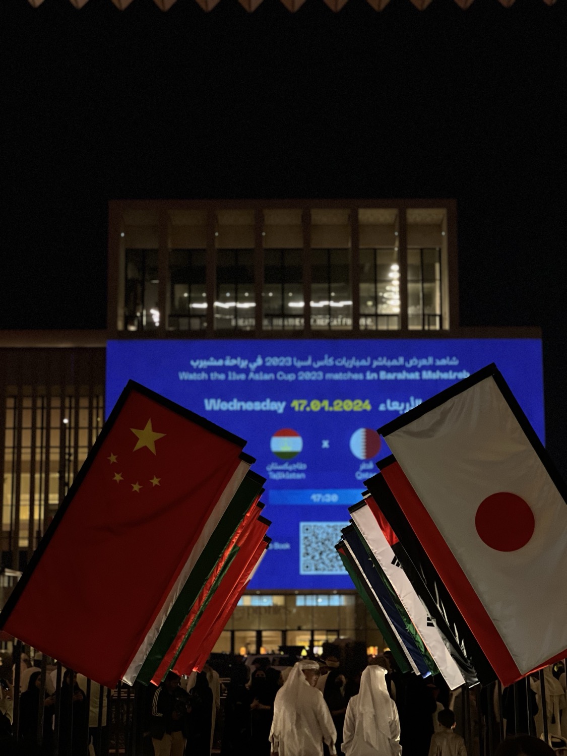 Screen announcing an Asian Cup fixture between flags, Barahat Msheireb, Doha