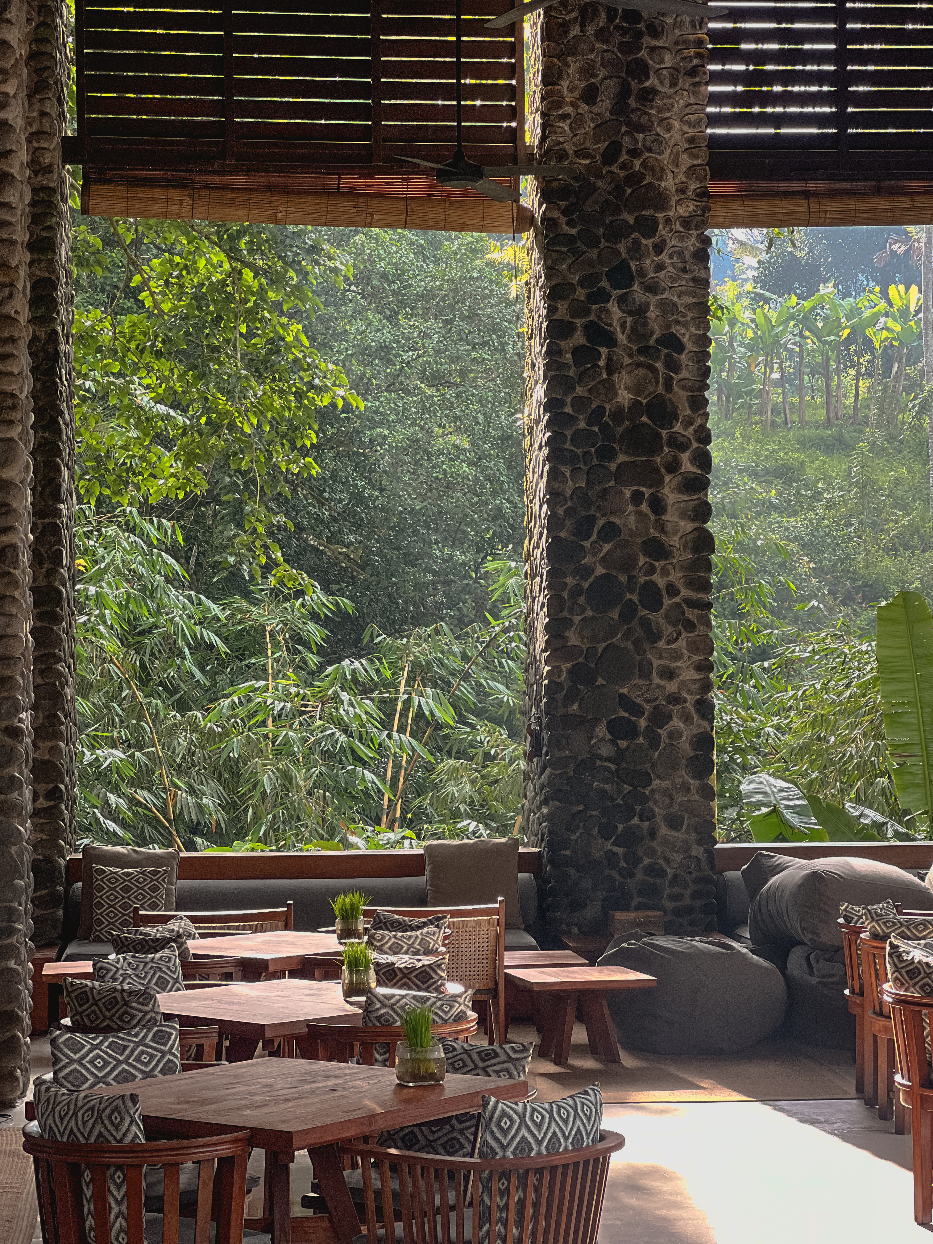 Open dining pavilion, stone columns, jungle beyond, Alila Ubud