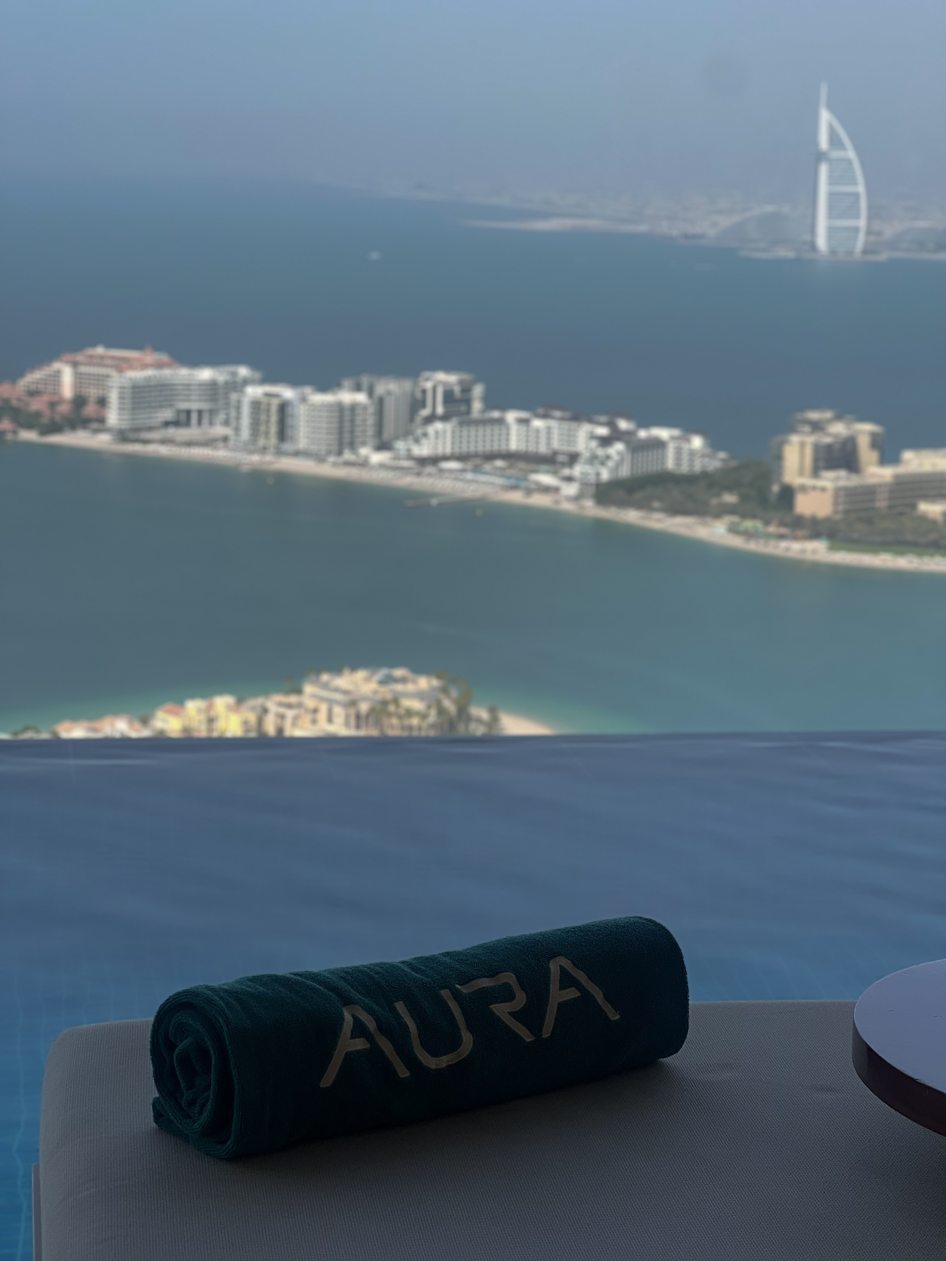 AURA towel on lounger, Burj Al Arab and Palm Jumeirah in the distance, Dubai