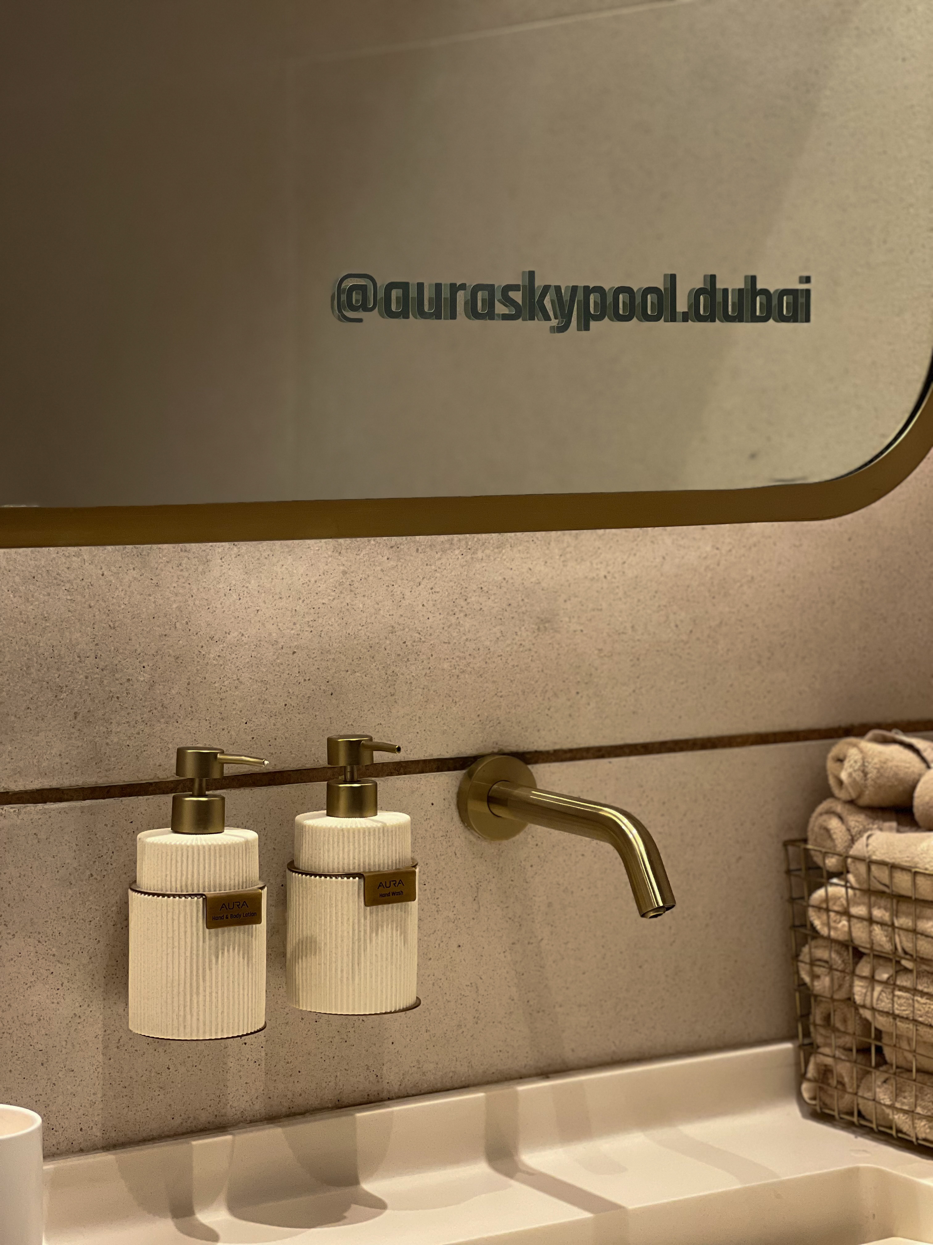 AURA branded bathroom interior, brass fittings and branded dispensers, Dubai