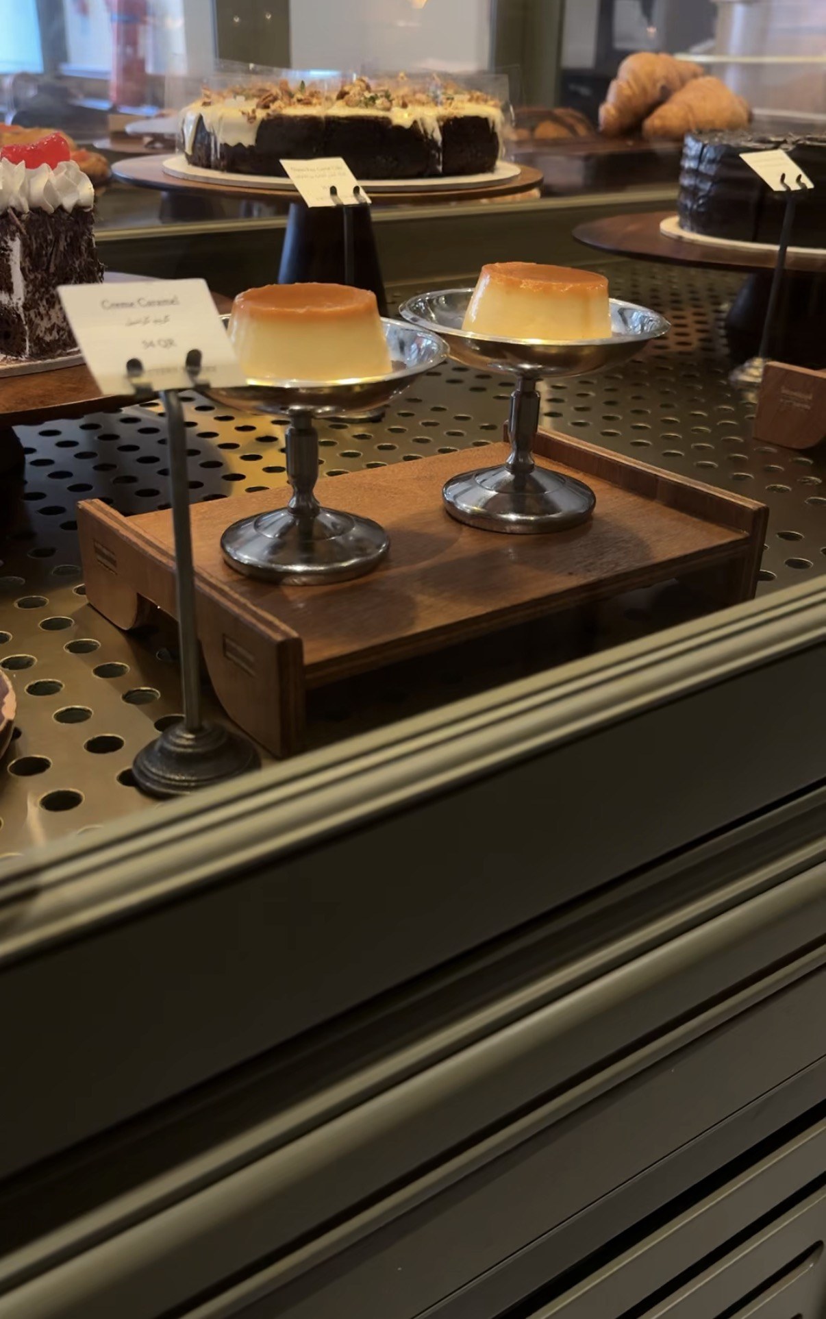 Cakes and crème caramel in the display case, The Buttery Bakery, Doha