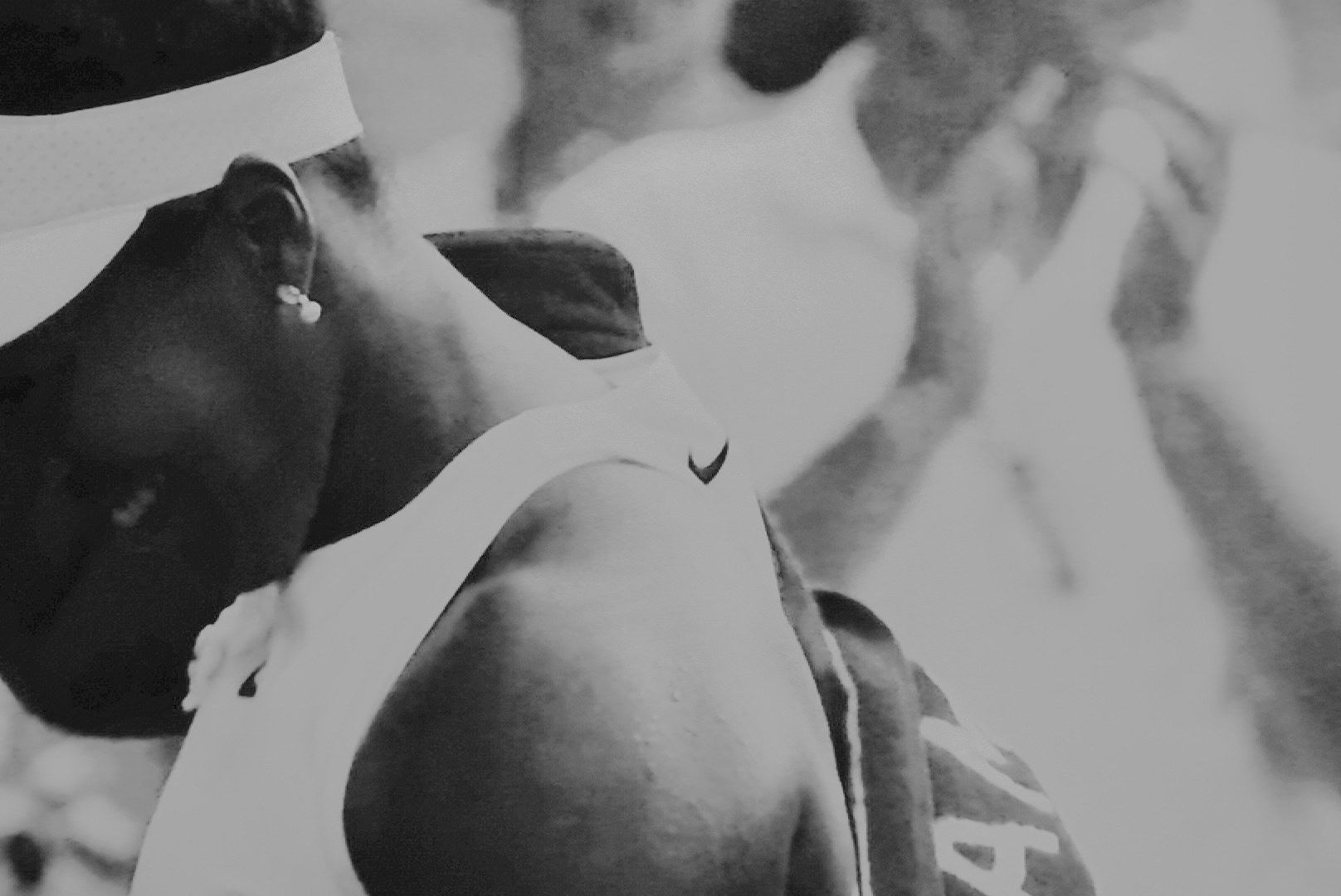 Close frame of a player's shoulder and ear, broadcast texture visible