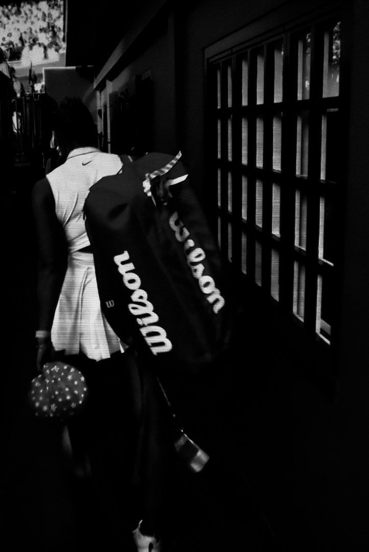 A player walking into darkness carrying a Wilson bag