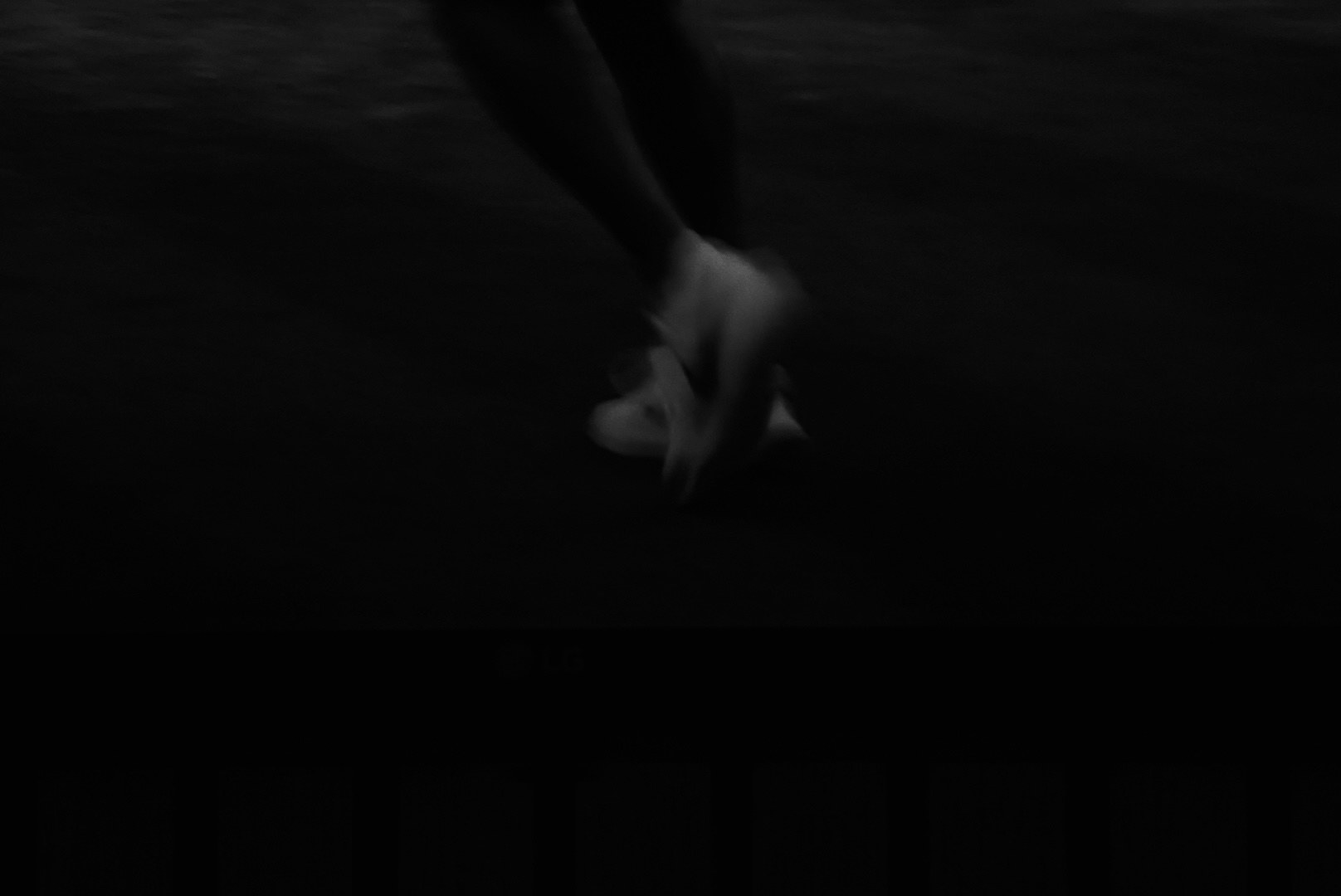 Feet mid-stride dissolving into the dark of the court