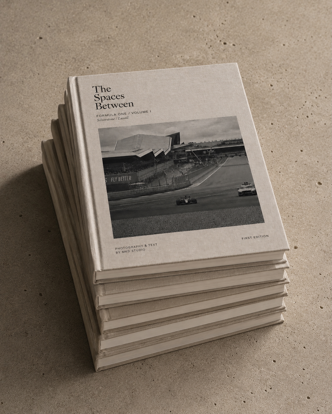 The printed first editions by mkd STUDIO, stacked, The Spaces Between uppermost