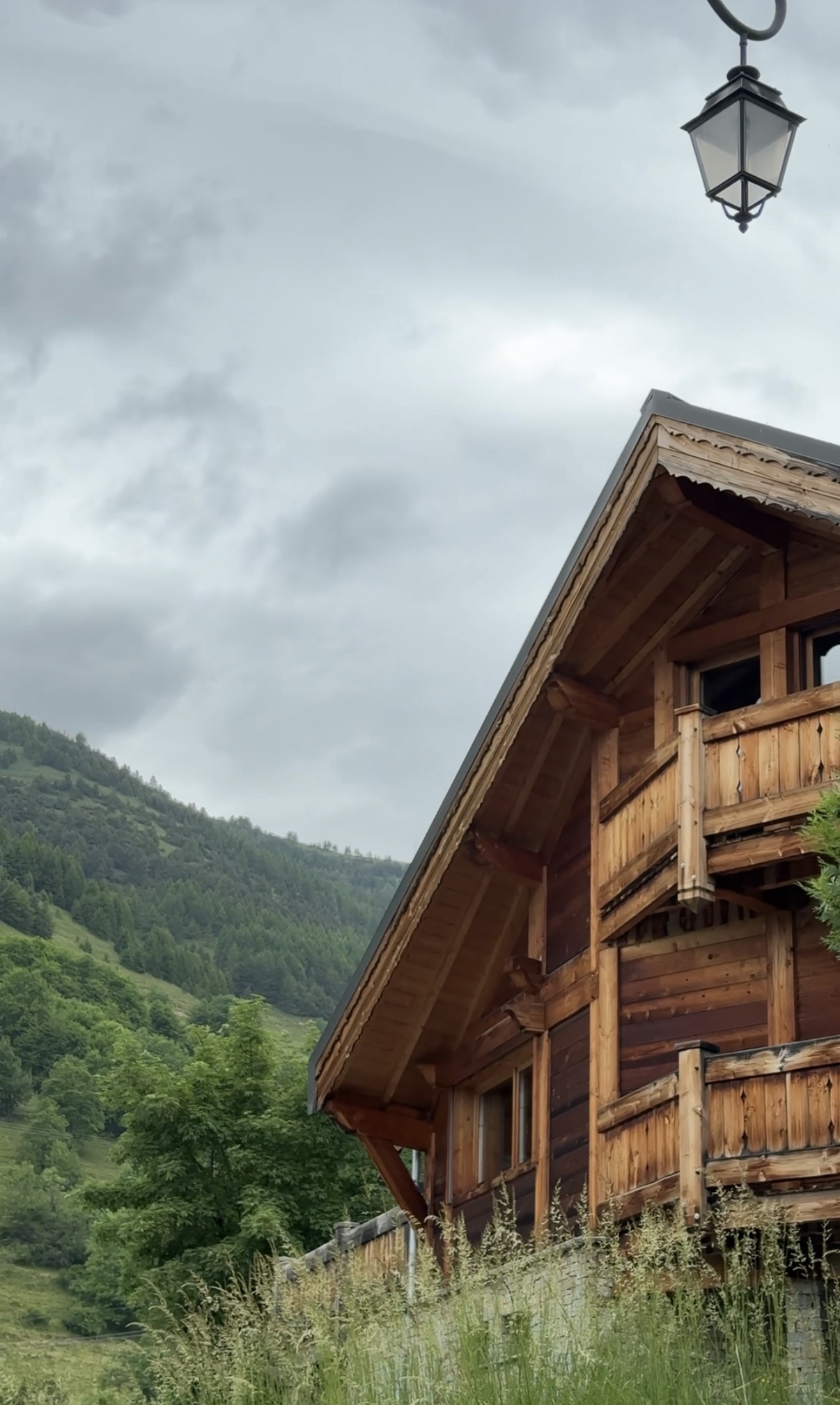 Timber chalet detail with lantern and valley below, French Alps