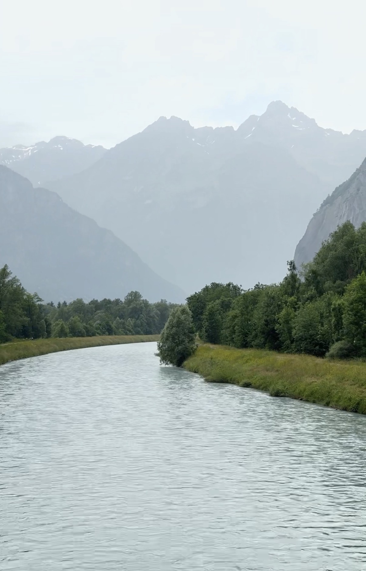 River through valley with misty mountains, French Alps