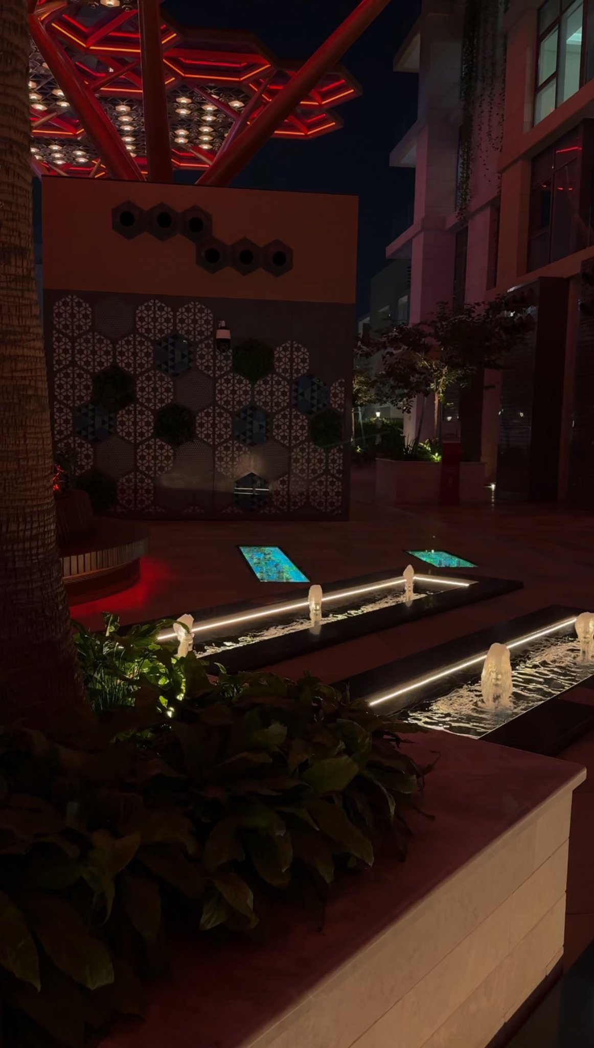 A red lit canopy above a planted courtyard corner, Gewan Island, Doha