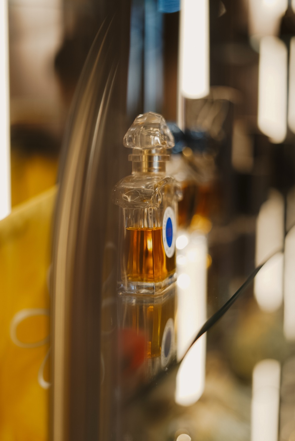 Guerlain bottle seen through curved vitrine glass, Leeds