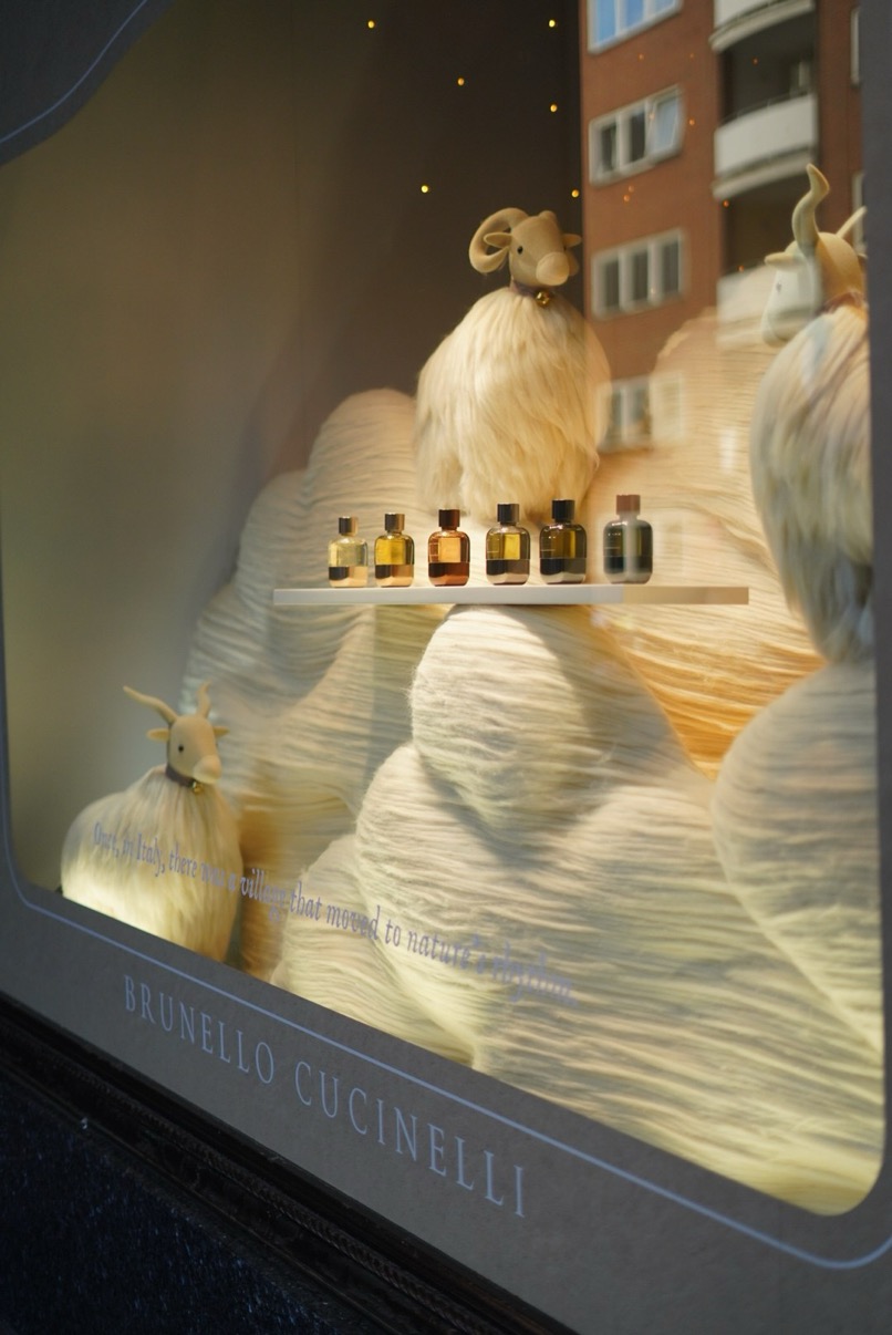 Brunello Cucinelli window display with white textile landscape and fragrance bottles, Harrods, London