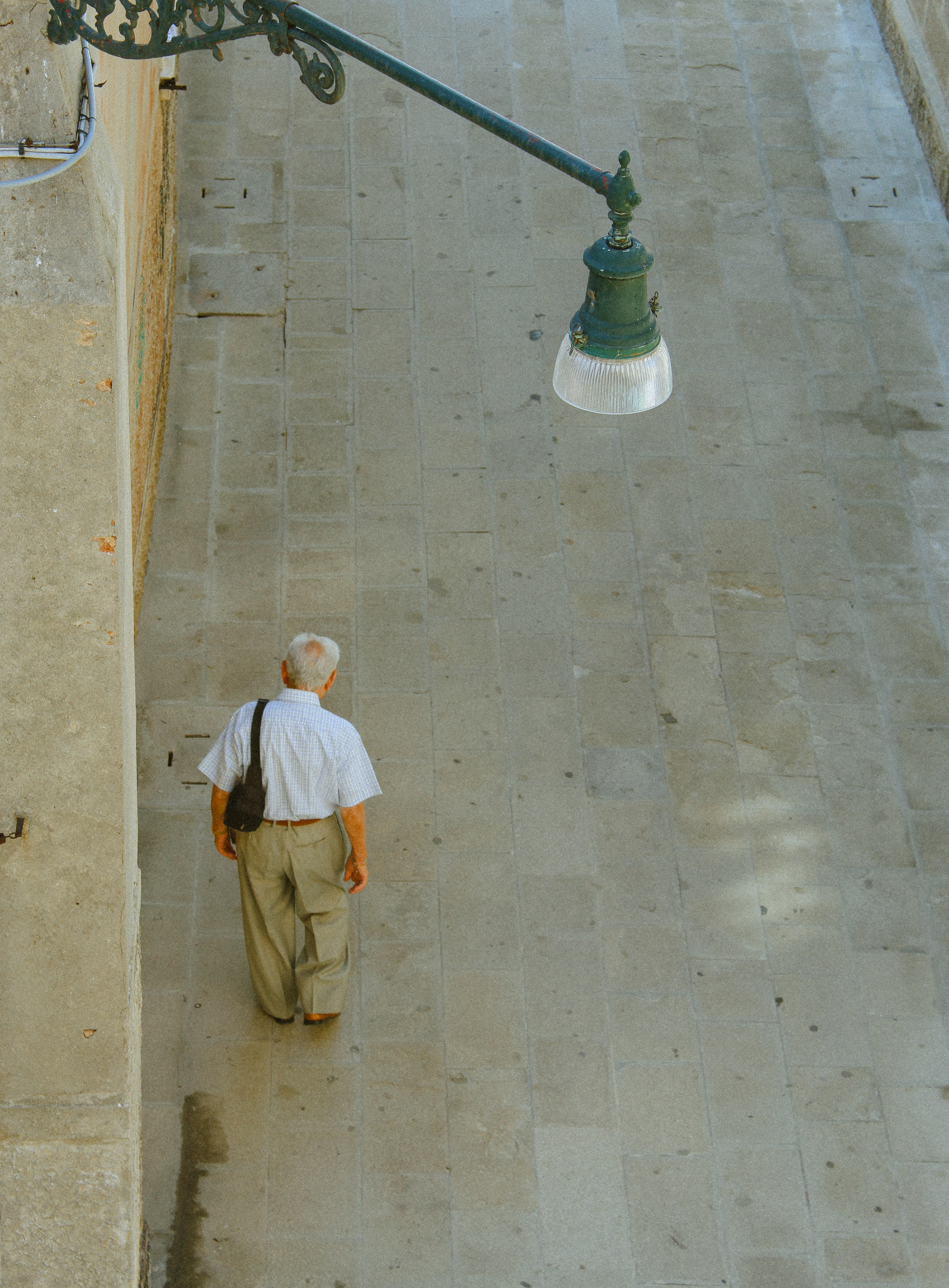 Man seen from above, ornate street lamp, Italia