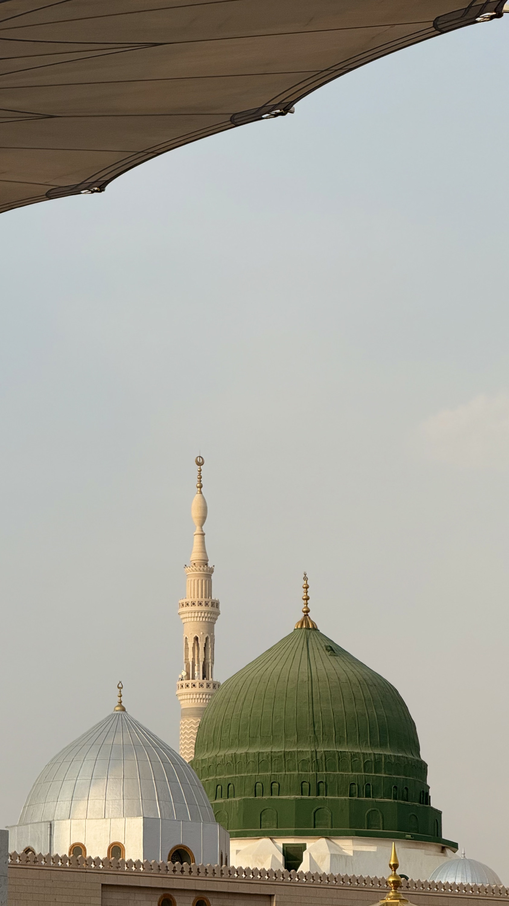 Green dome of Al-Masjid an-Nabawi with minaret and umbrella shade, Madinah al-Munawwarah