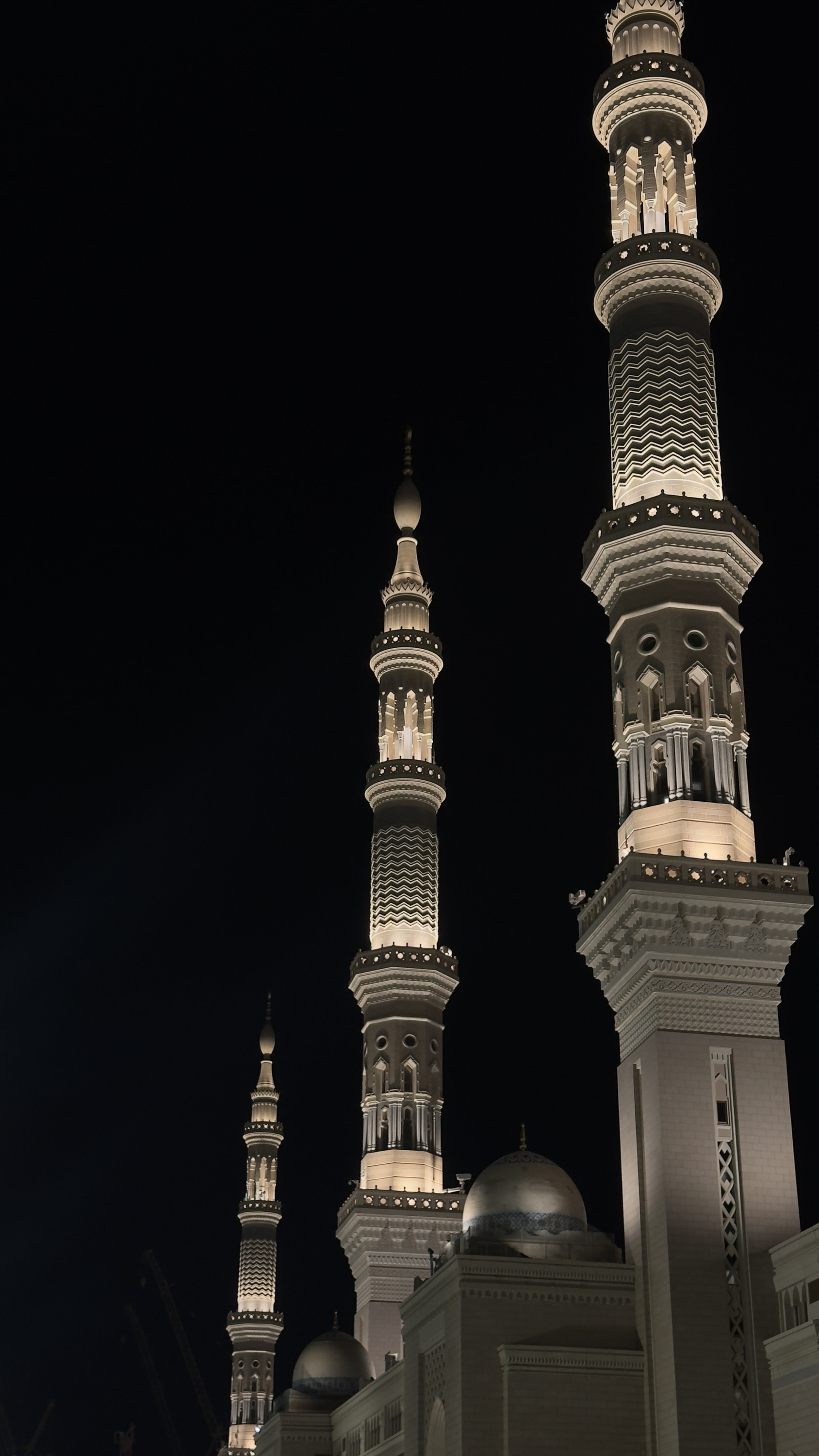 Three minarets of Al-Masjid an-Nabawi lit at night, Madinah al-Munawwarah