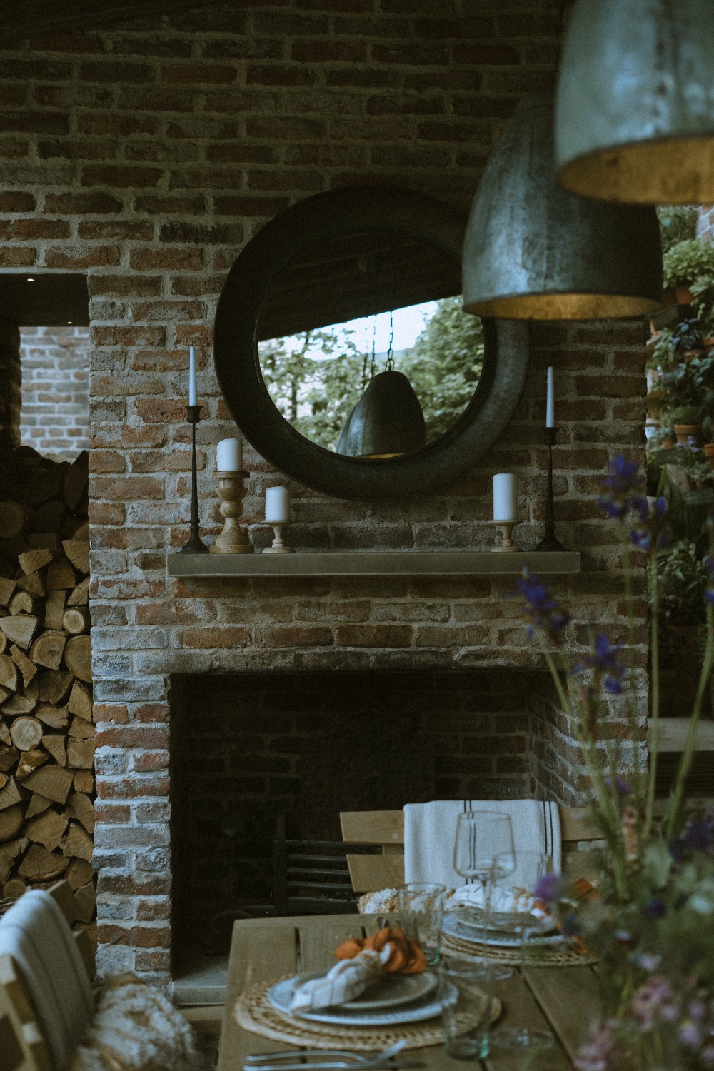 The fireplace with a round mirror and candles on the mantel, The Savills Garden, RHS Chelsea Flower Show, London