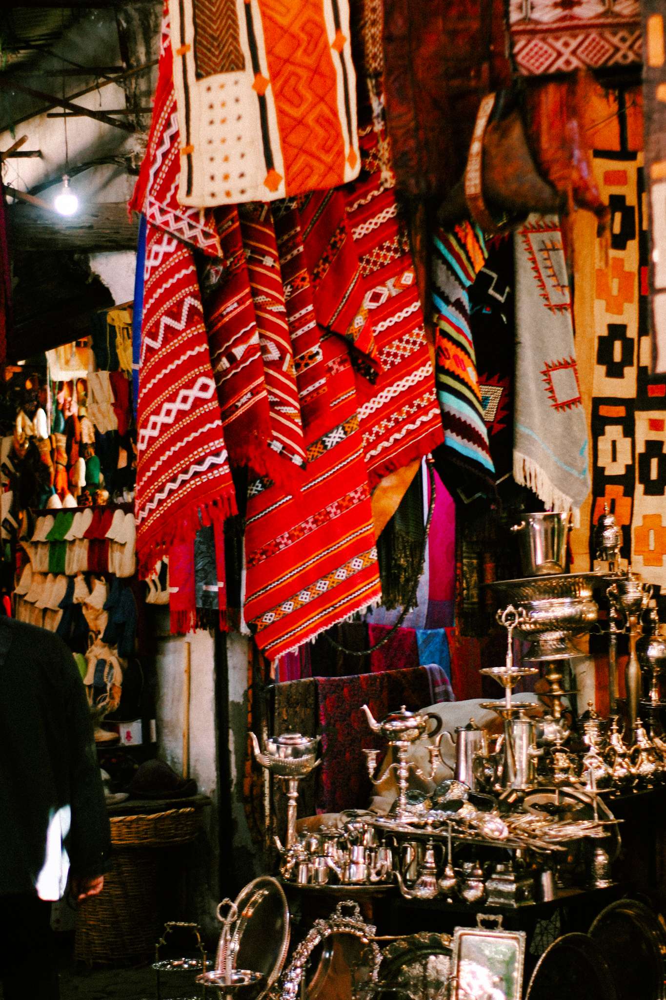 Woven textiles and silver above a souk stall, Marrakech