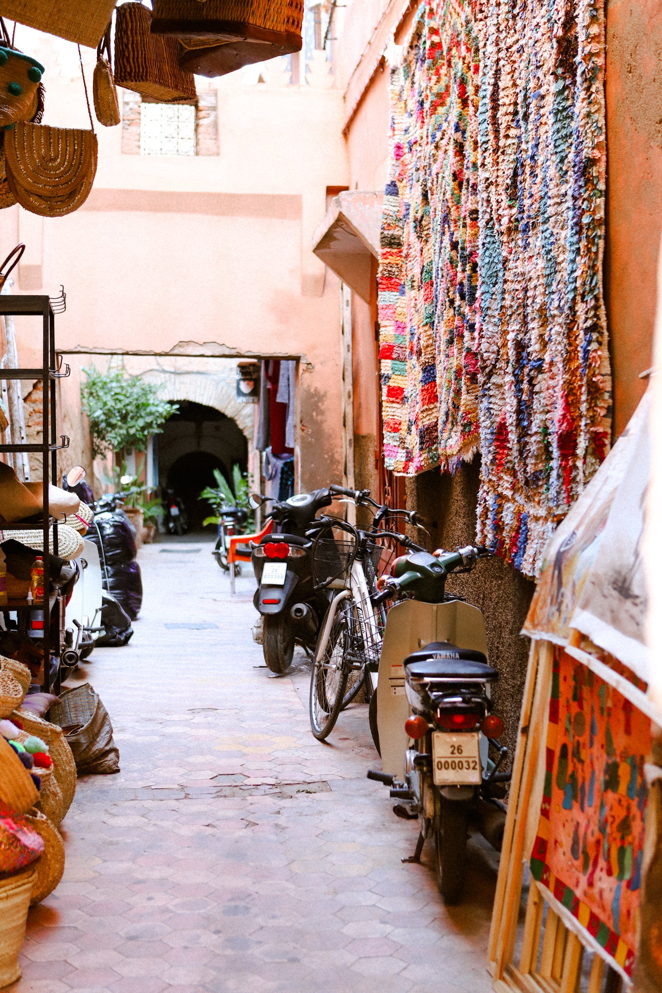 Rag rugs and parked motorbikes in a narrow lane, Marrakech
