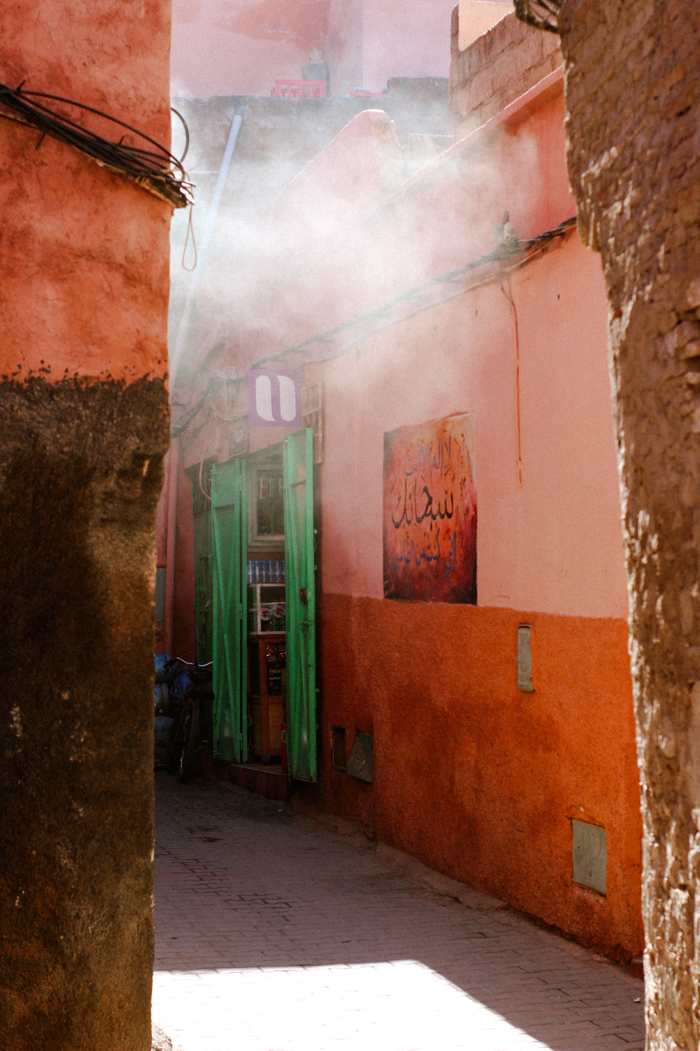 Light and dust in a lane between ochre walls, Marrakech