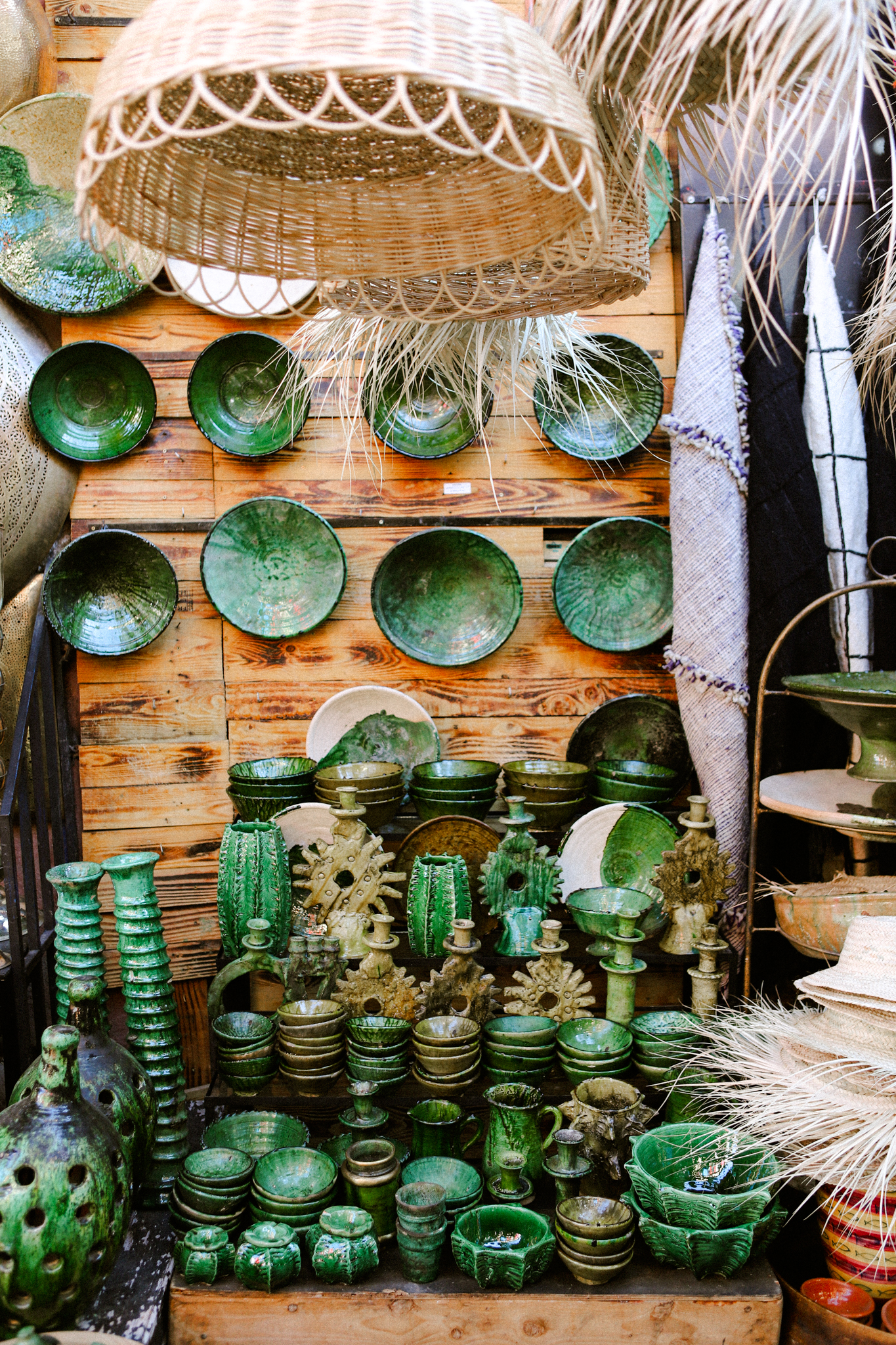 Green glazed pottery stacked against wood, Marrakech