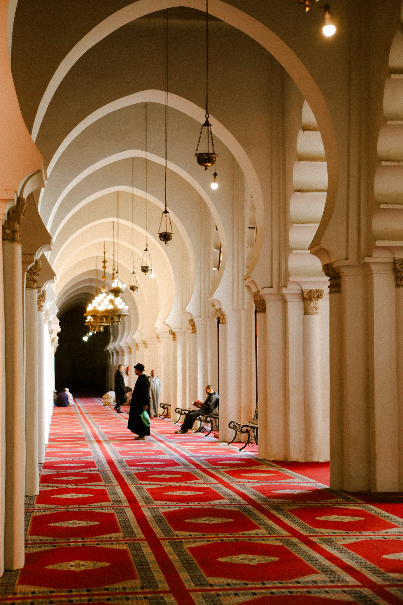 The arcade of a mosque, red carpet and lamplight, Marrakech
