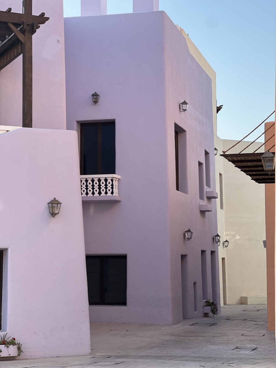 Lavender and sand façades with wall lanterns, Mina District, Doha