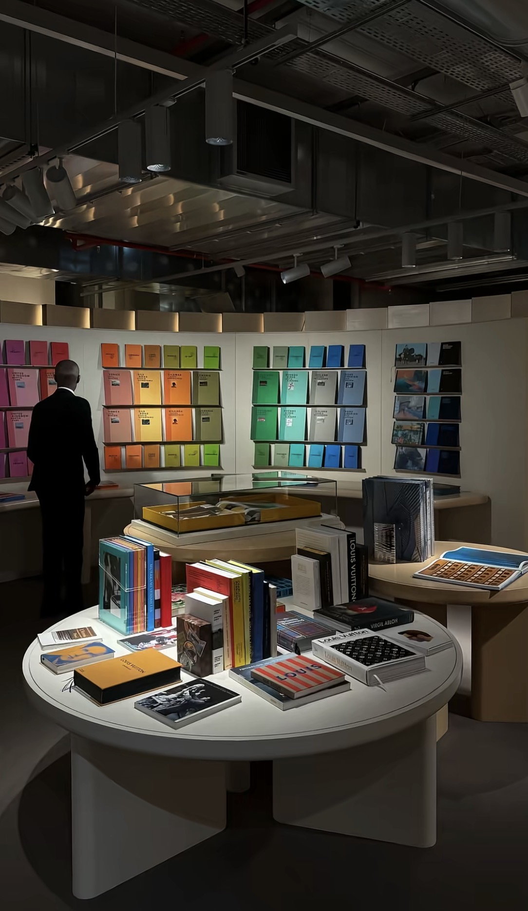 Room of colour-graded books and stationery arranged by spine