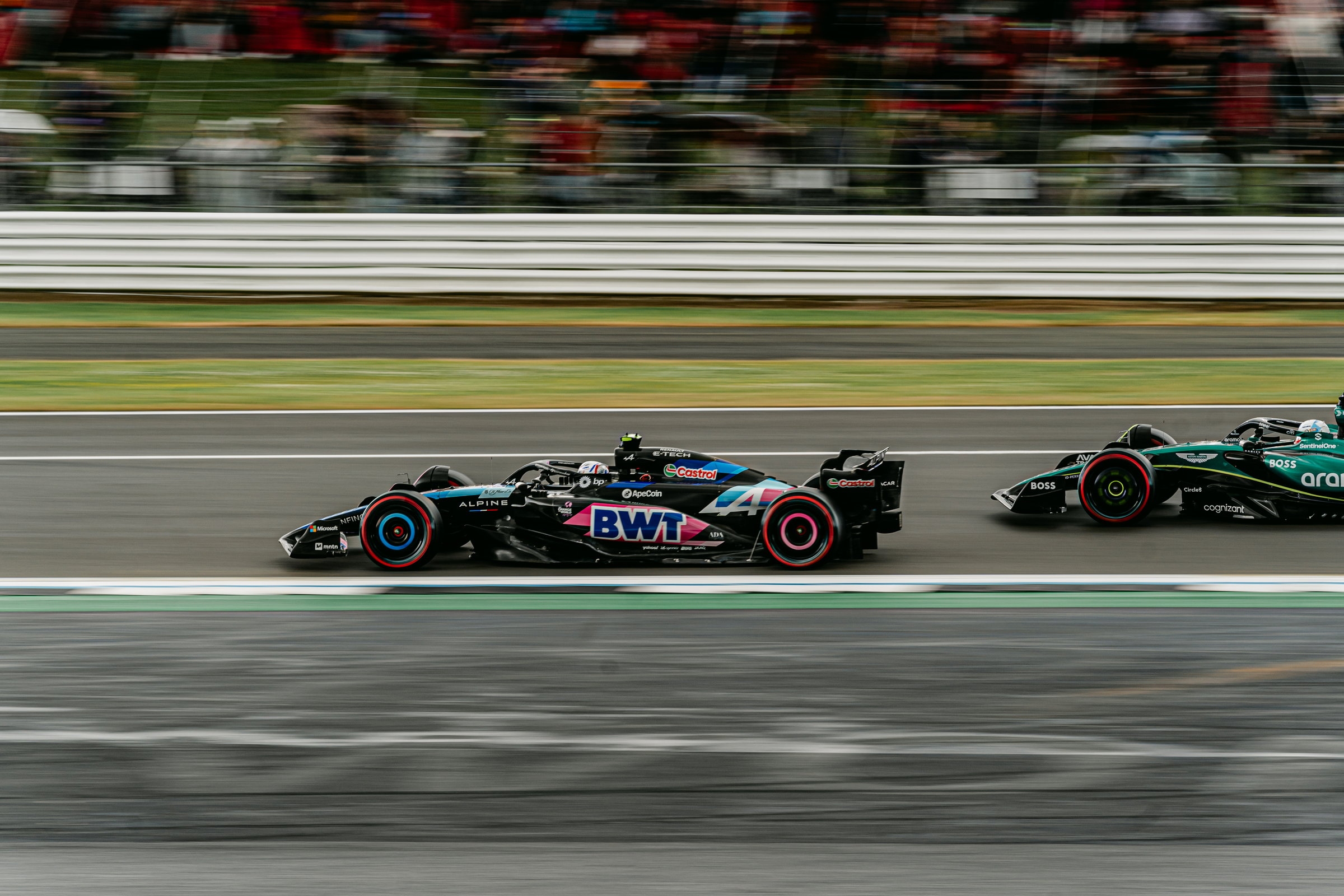 Alpine and Aston Martin F1 cars side by side at speed, motion blur, Silverstone