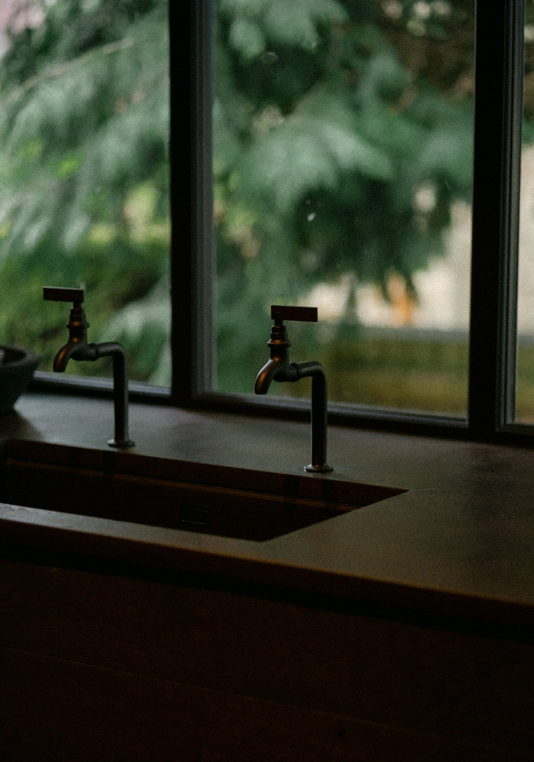 Brass taps at a dark counter