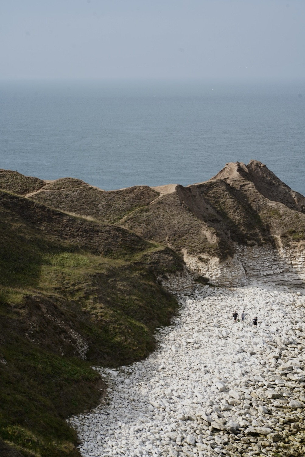White chalk cliffs and figures on the beach