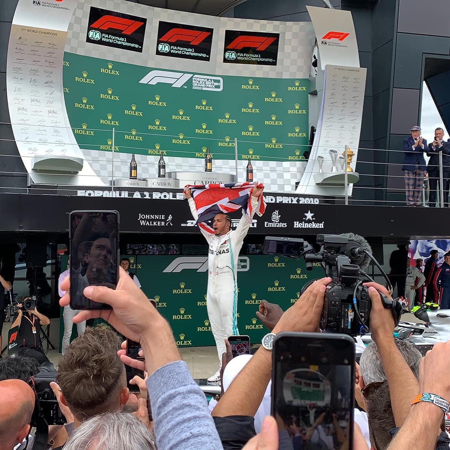 Lewis Hamilton raising the Union Jack flag on the Silverstone podium