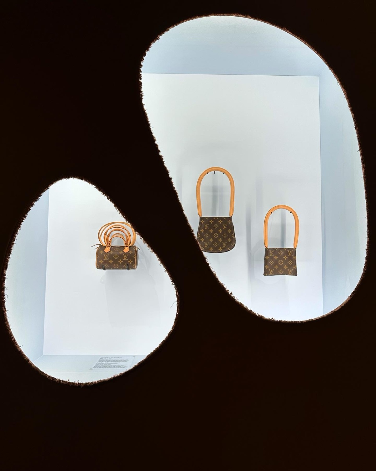 Louis Vuitton monogram bags displayed in egg-shaped illuminated window cutouts