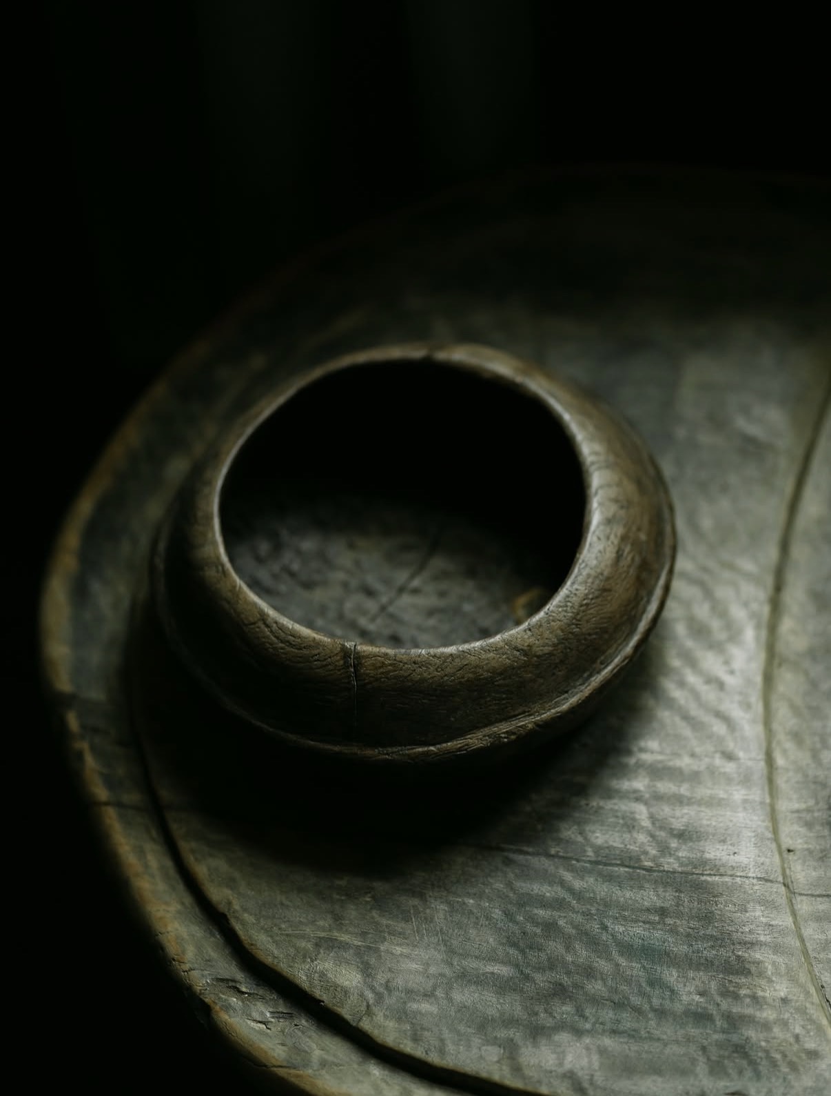 Dark wooden bowl on worn timber plate, The Penny Bun, Askwith.