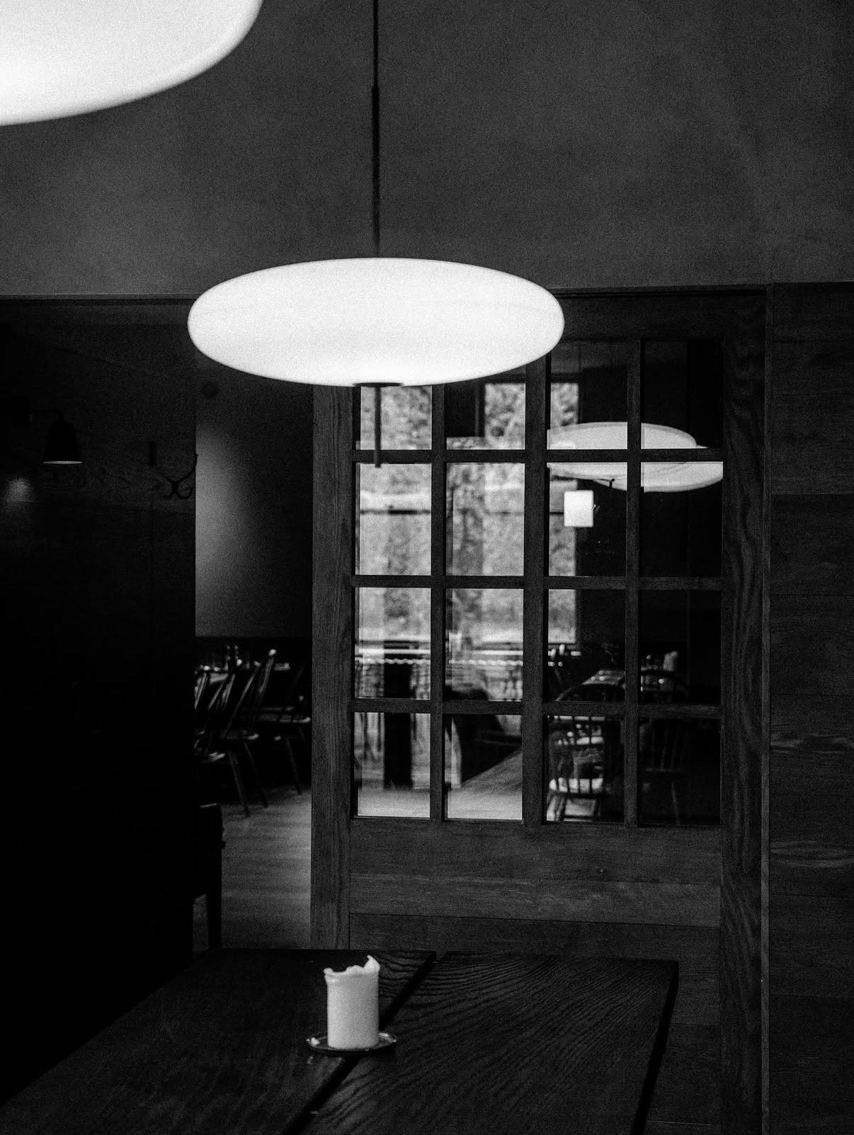 The Penny Bun interior, Askwith, Yorkshire. Globe pendant light and gridded glazed partition.