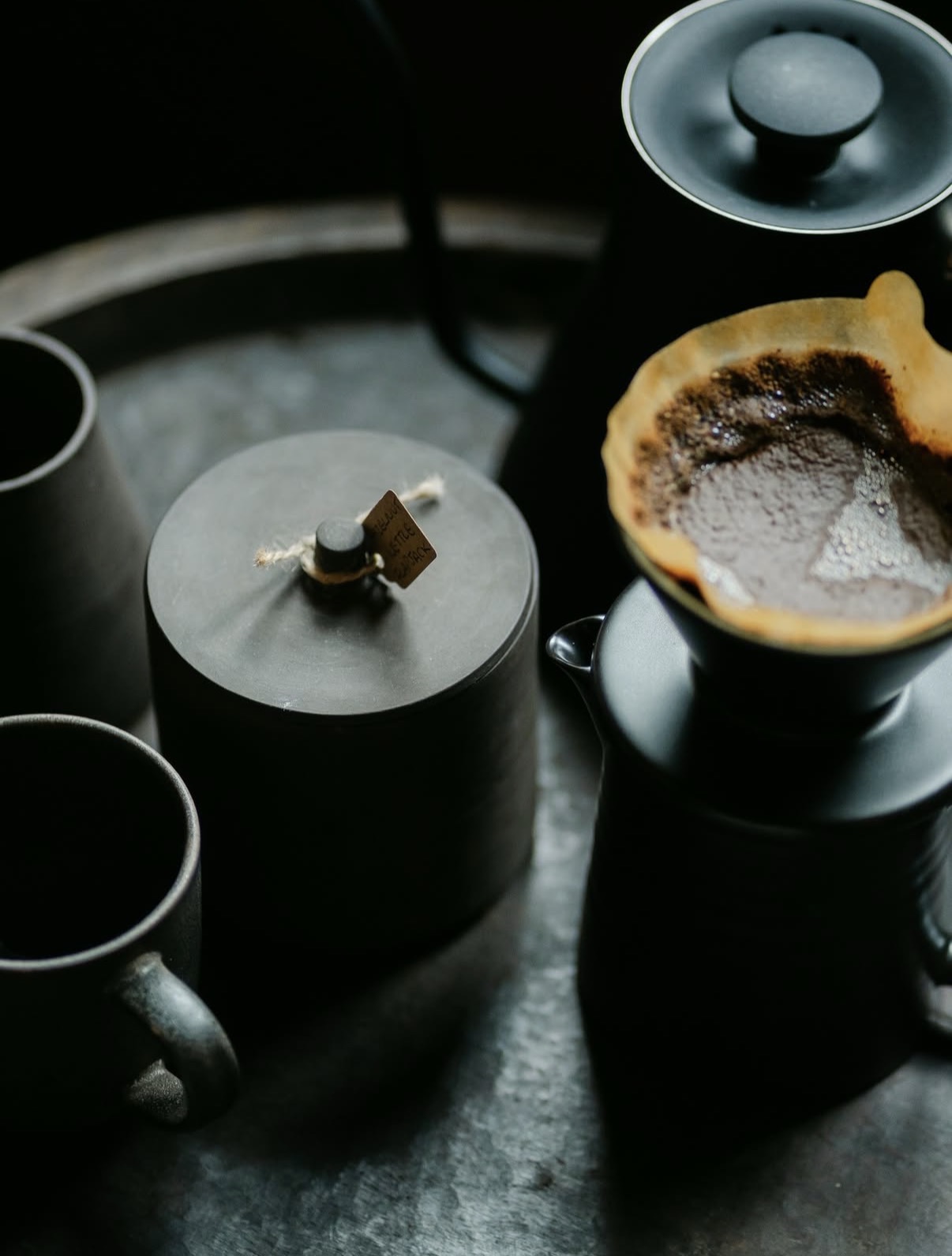 Pour-over coffee set on tray with dark ceramic cups and filter cone, The Penny Bun, Askwith.