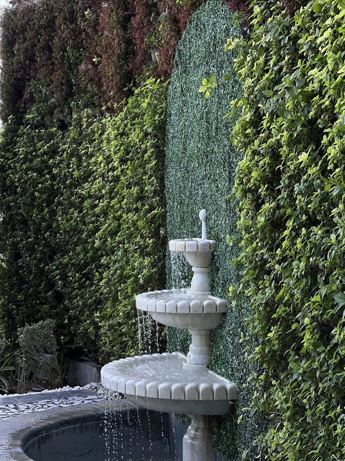 Marble fountain against the green wall, Raffles Doha hotel