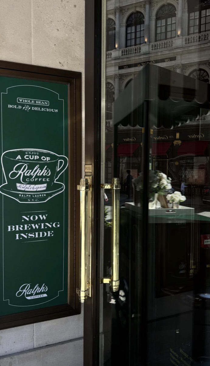 Ralph's Coffee green door sign reading Now Brewing Inside with brass handle and street reflection, London