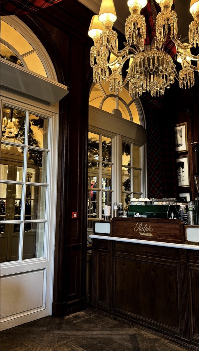 Ralph's Coffee dark wood counter with crystal chandelier above and arched windows, London interior
