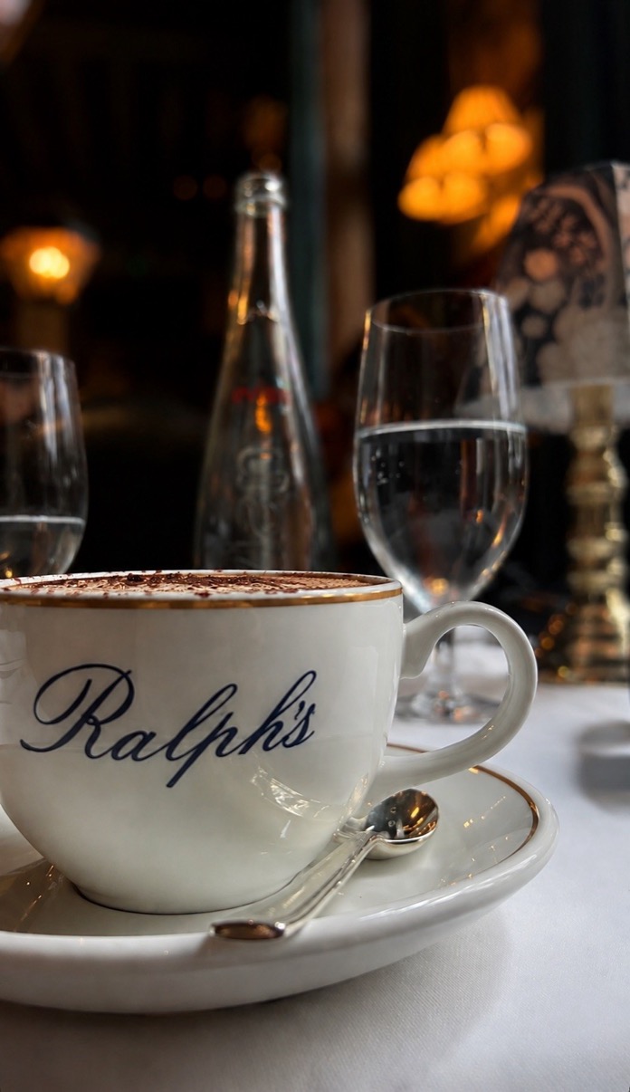Ralph's white porcelain cappuccino cup in warm candlelight with a water glass behind, London