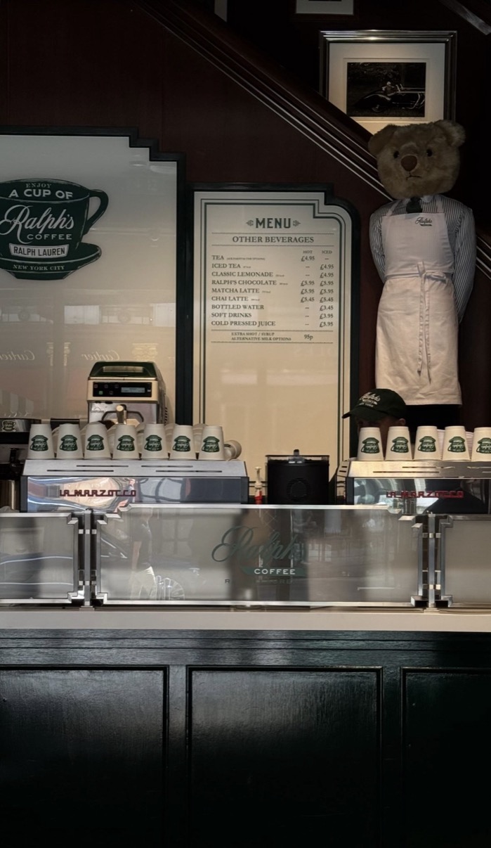 Ralph's Coffee counter with branded cups, La Marzocco machines and Ralph Lauren bear mascot in apron, London