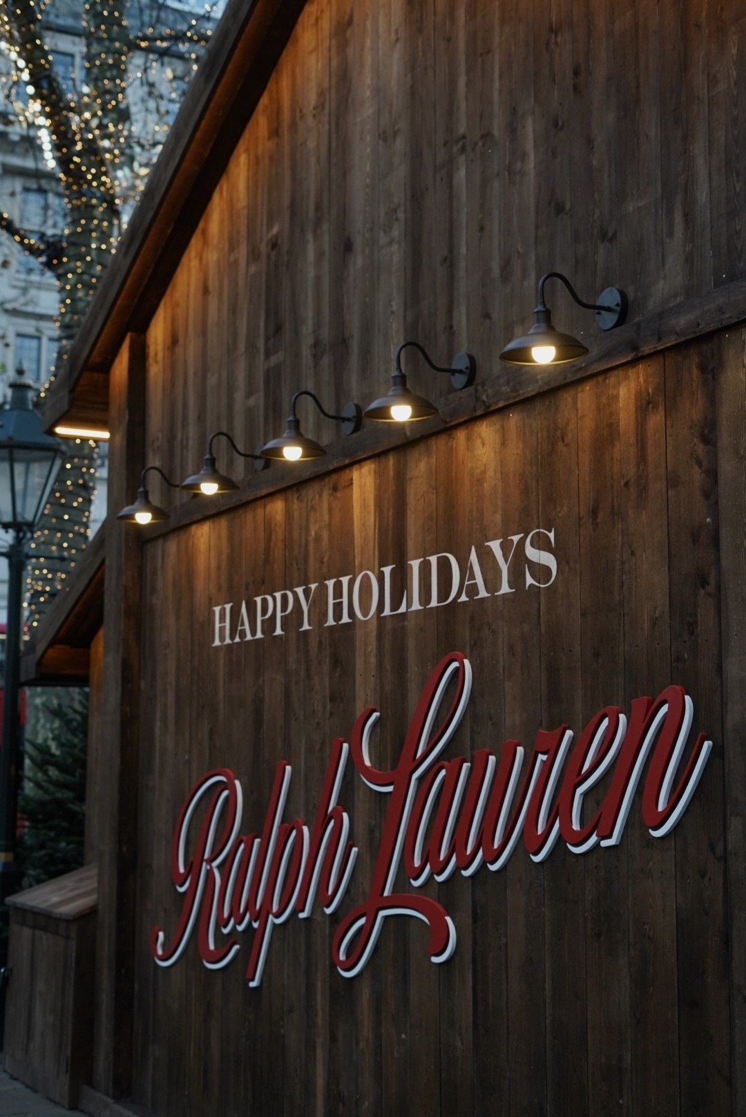 Happy Holidays, Ralph Lauren script lit from above on a timber wall, London