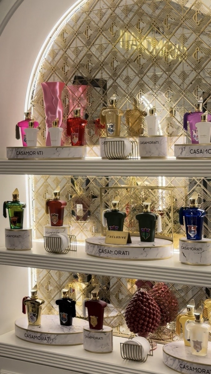Rows of Casamorati perfume bottles on arched shelves with gold lattice backing, Salon de Parfums, Harrods, London