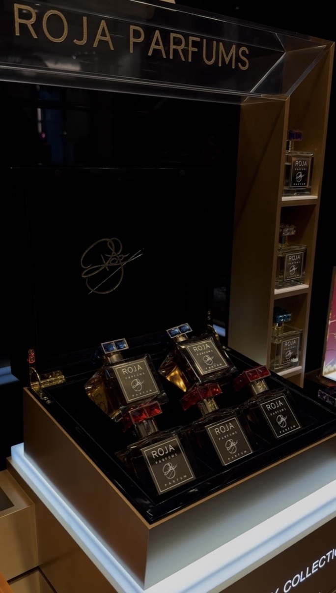 Roja Parfums display case with gold-topped bottles arranged on a dark lacquered surface, Salon de Parfums, Harrods, London