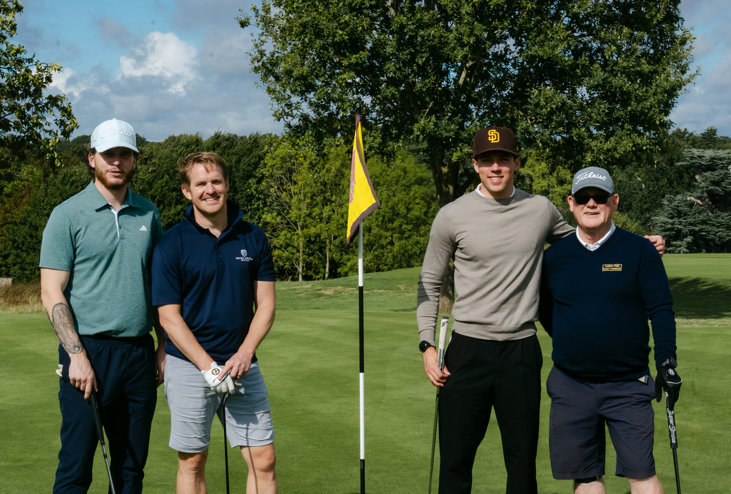 Four players standing together at the flag, McLaren Construction Group Golf Day, Rochester & Cobham Park, Kent