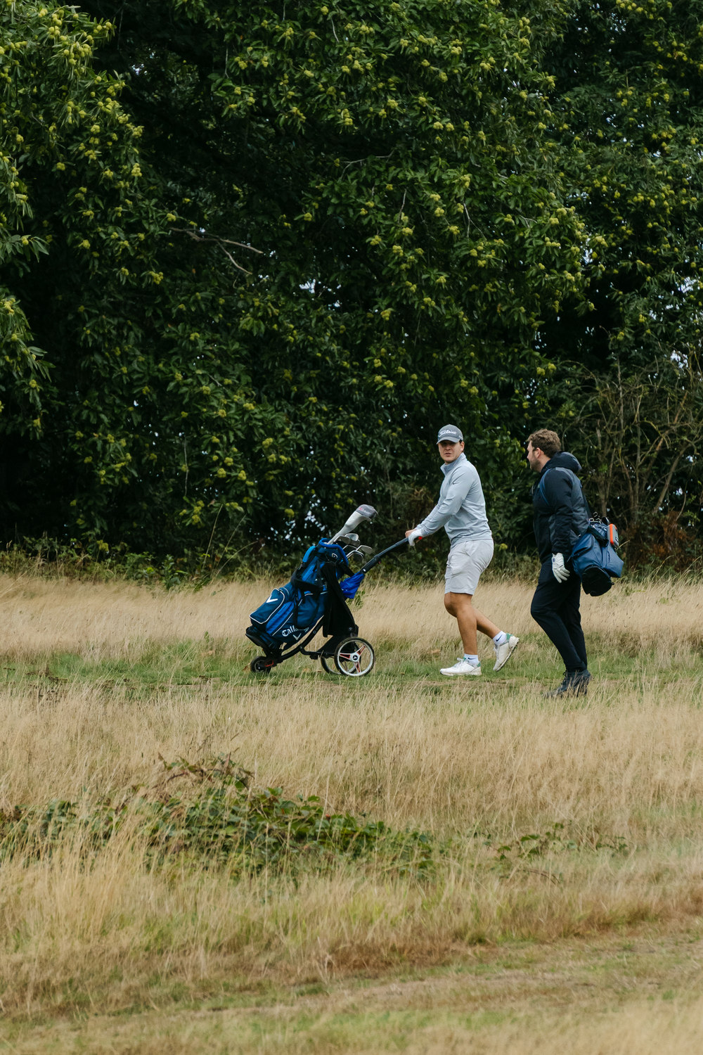 Two figures crossing the rough at a distance, Rochester & Cobham Park, Kent