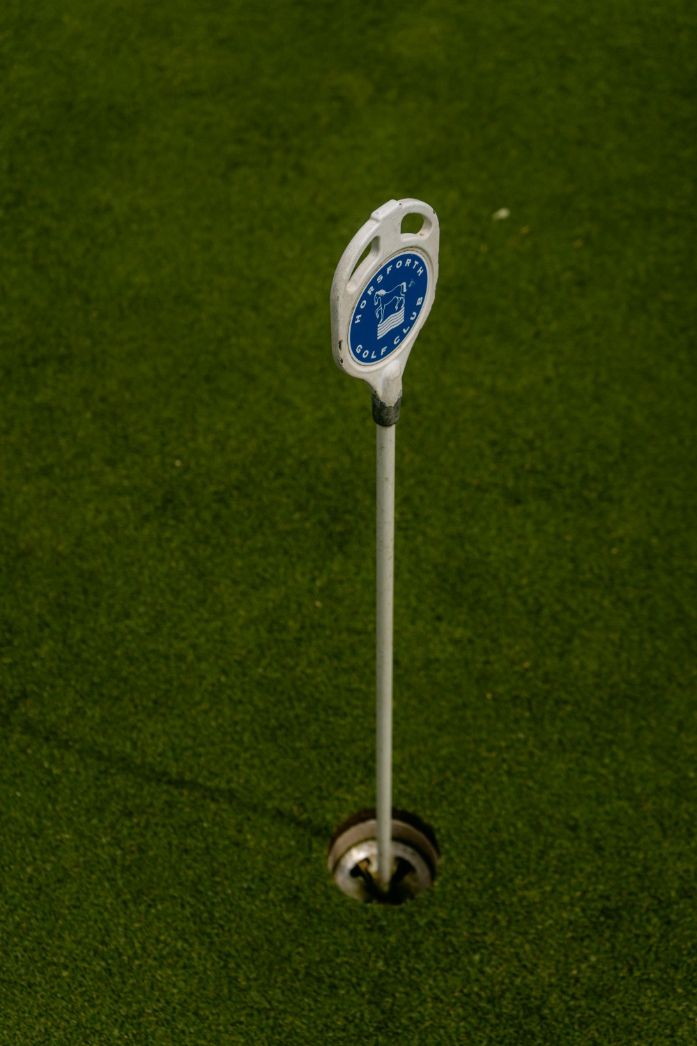 A hole marker standing in the cup of the putting green, Magnolia Classic, Horsforth Golf Club, Leeds