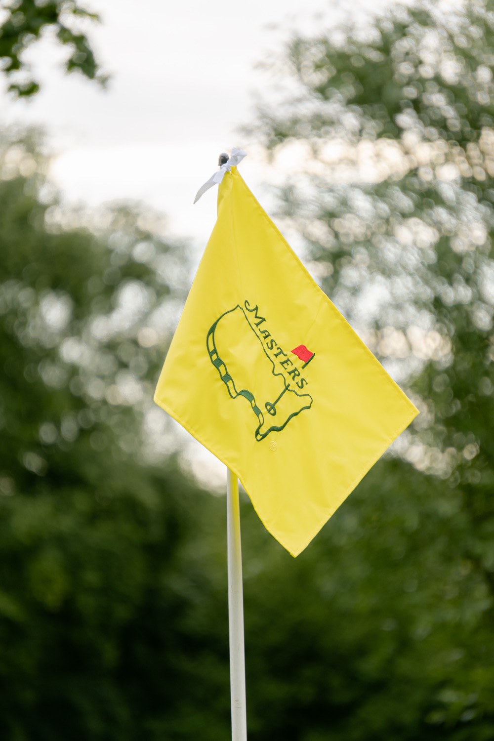 A yellow Masters flag moving against the trees, Magnolia Classic, Horsforth Golf Club, Leeds