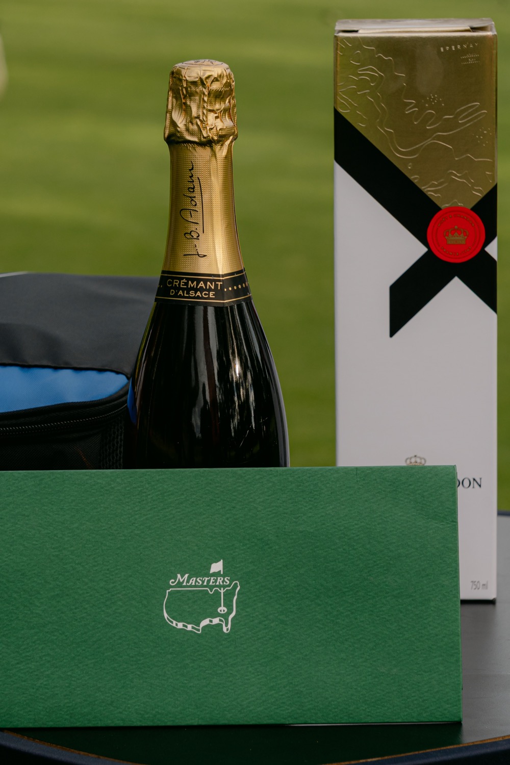 A bottle, a gilded box and an envelope in Masters green at the end of the day, Magnolia Classic