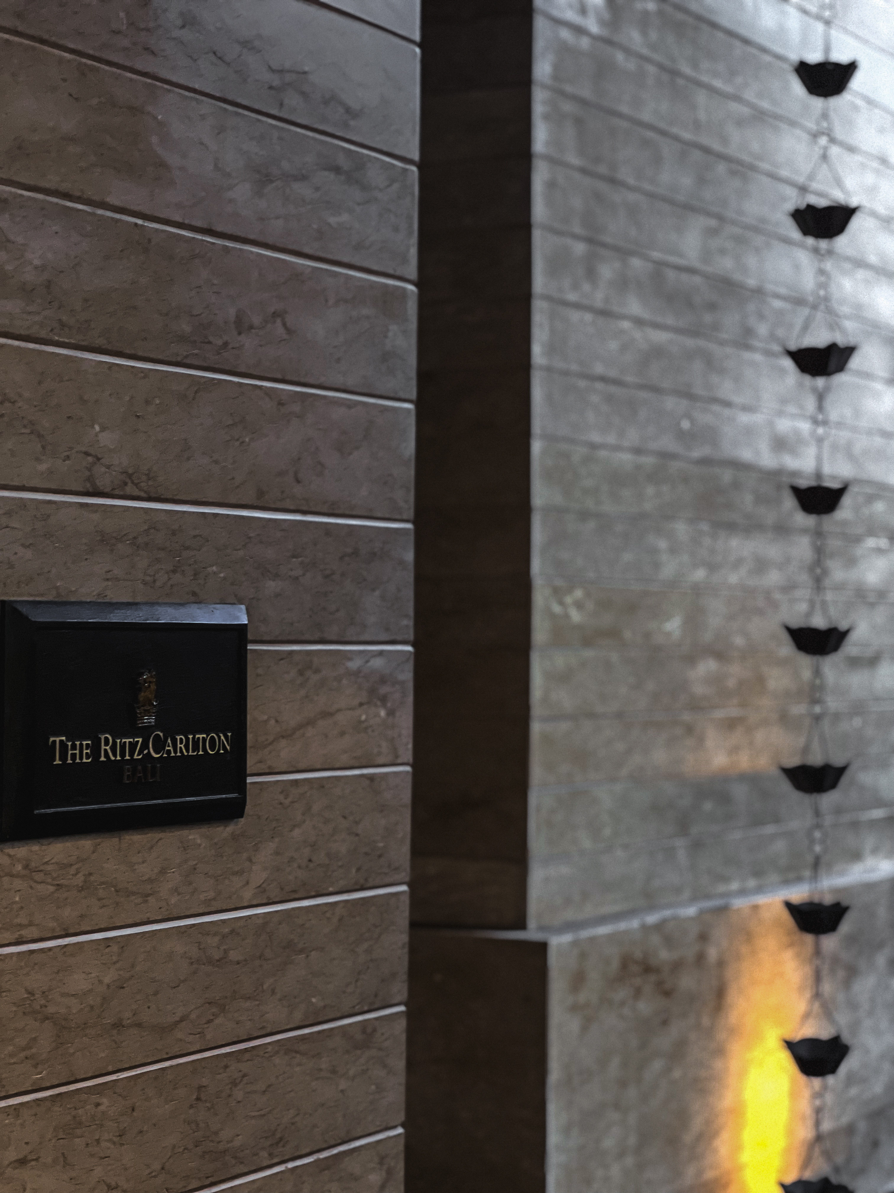 The Ritz-Carlton, Bali plaque on stone wall with rain chain