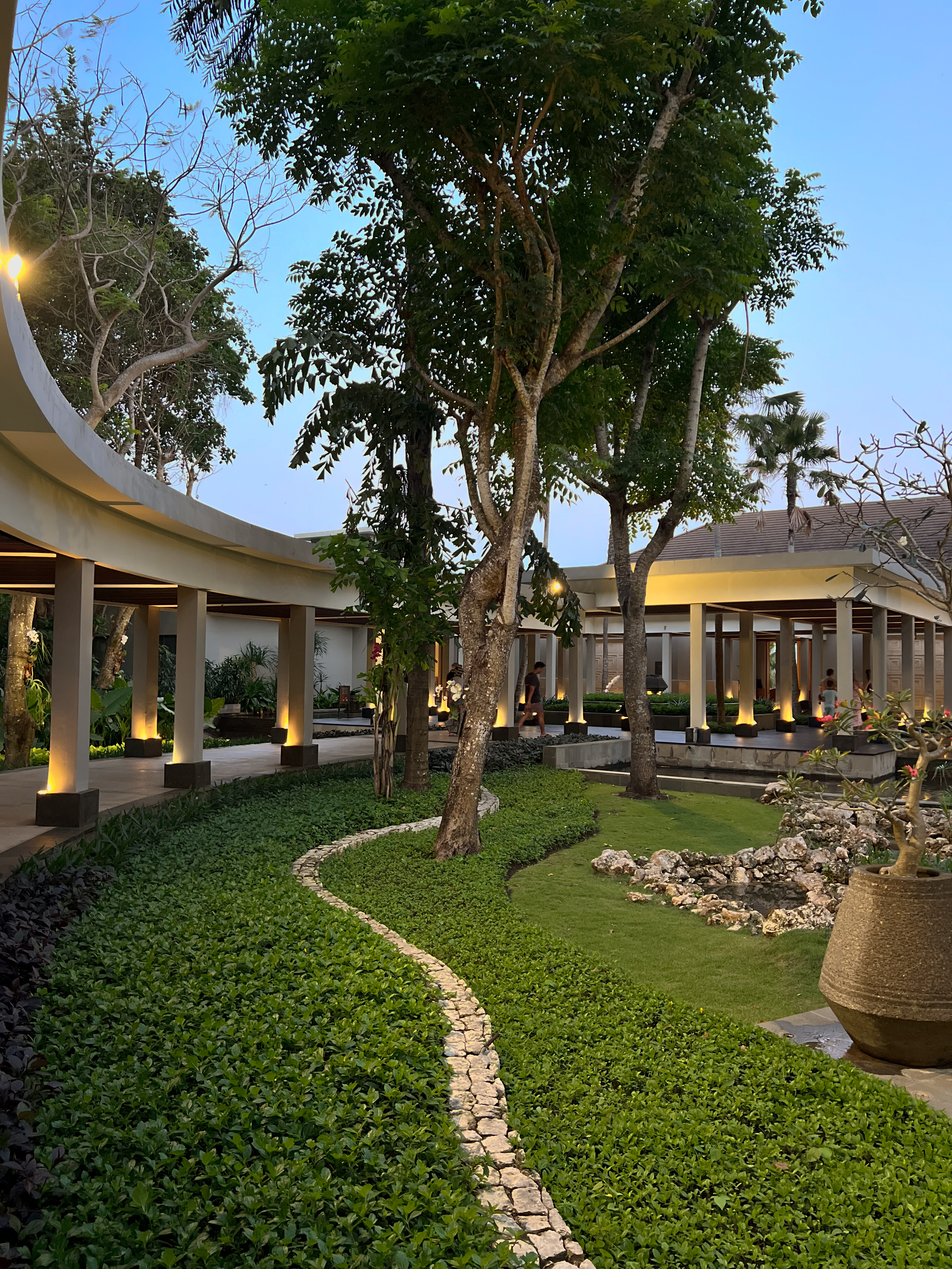 Curved courtyard walkway at dusk, colonnade and garden, The Ritz-Carlton Bali