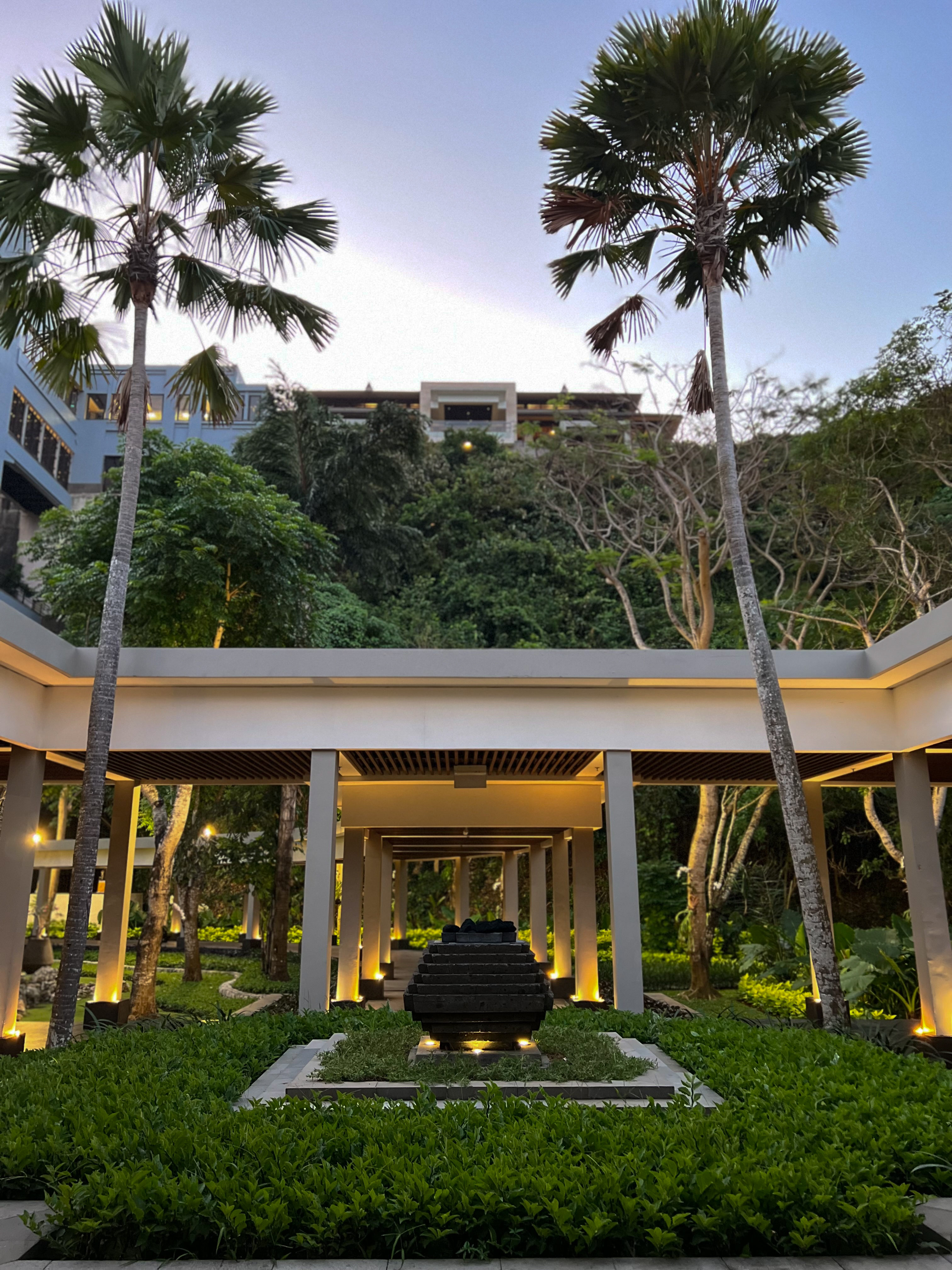 Palm courtyard at dusk, dark sculpture, colonnade, The Ritz-Carlton Bali